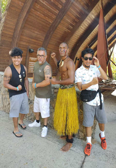 Me, my brother and father standing next to a polynesian performer.