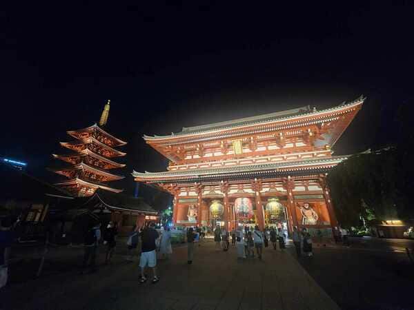 This image shows a famous buddhist temple in Asakusa, Japan called Senso-ji. The image was taken 
        at night showing the red temple beautifully lit up.