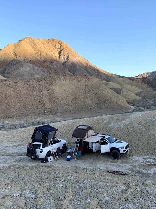 This image shows a camping car setup with rooftop tents on the cars