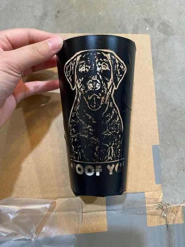 This image shows a black stencil of a labrador retriever on a glass cup.