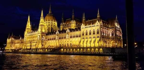 This image shows a lit up castle in Budapest called the Buda Castle.
